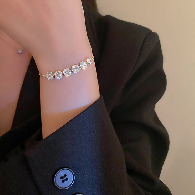 Detalhe da Pulseira Luxor usada com blazer preto, realçando o contraste entre brilho e alfaiataria elegante