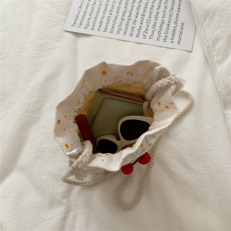 Bolsa Cherry de lona aberta mostrando espaço interno para celular e acessórios do dia a dia.