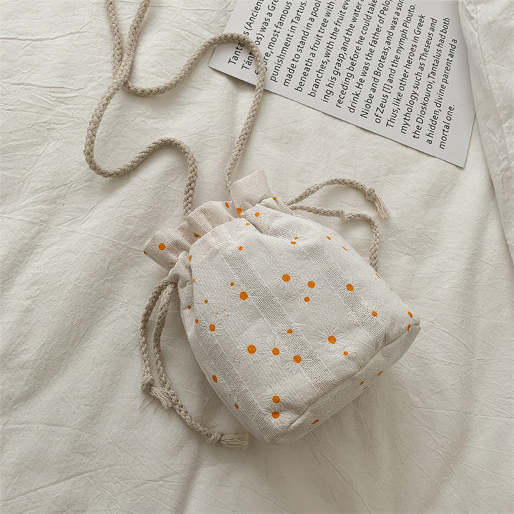 Bolsa Cherry de lona vista de costas, formato saco com cordão ajustável e estampa de margaridas.