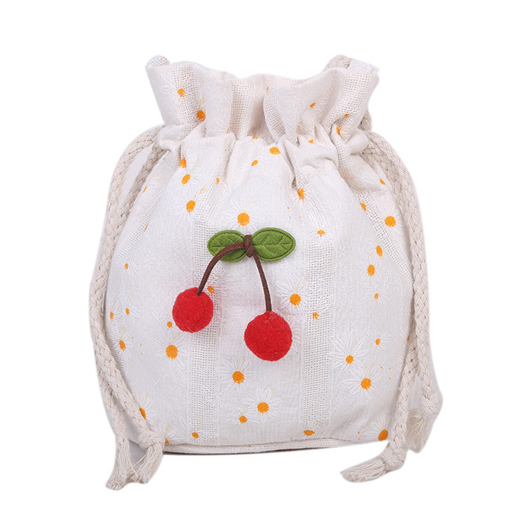 Bolsa Cherry em lona com aplicação de cerejas bordadas em relevo e estampa delicada de margaridas.