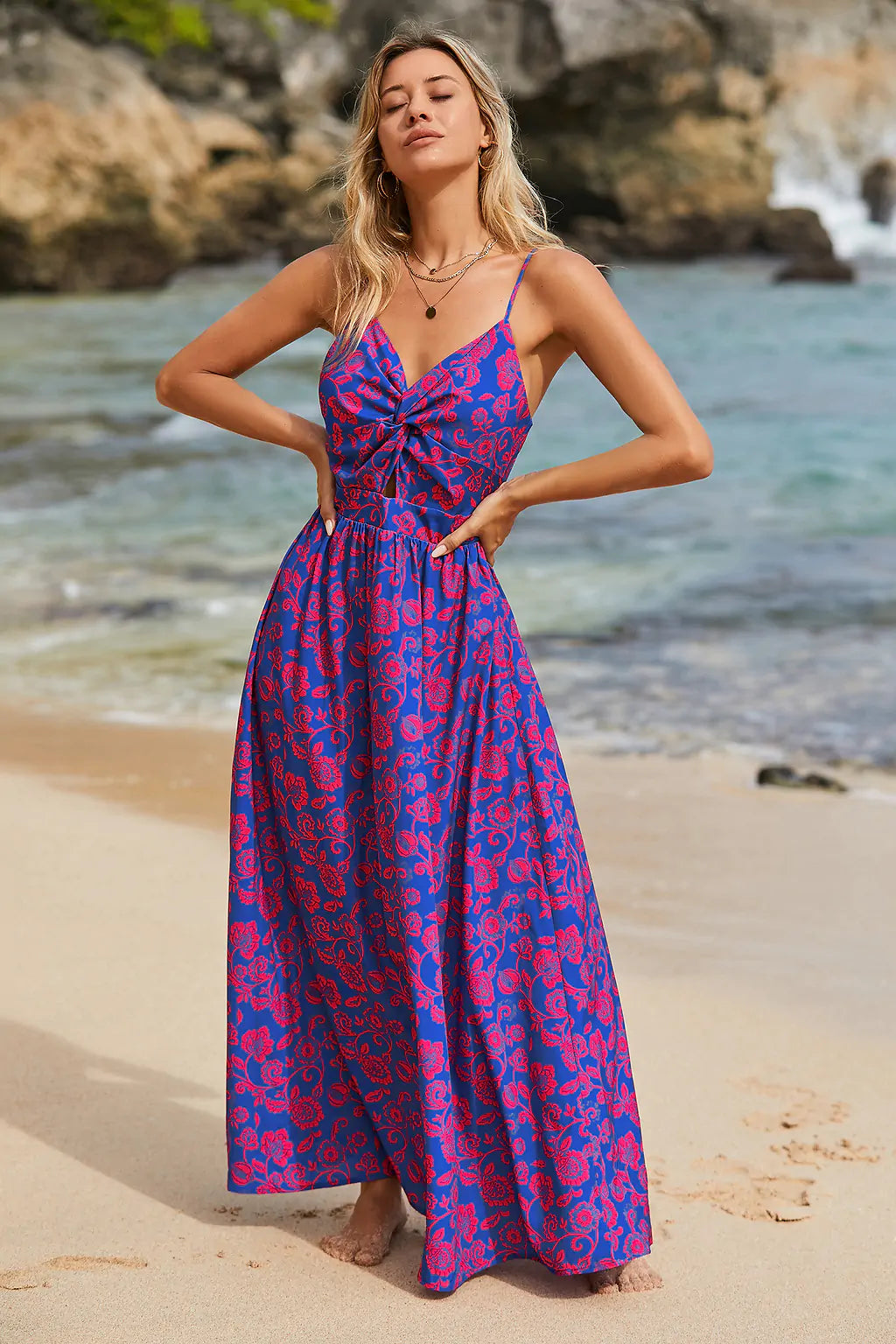 Vista lateral e traseira do vestido longo roxo floral com alças finas, usado com chapéu na mão, perfeito para dias ensolarados.