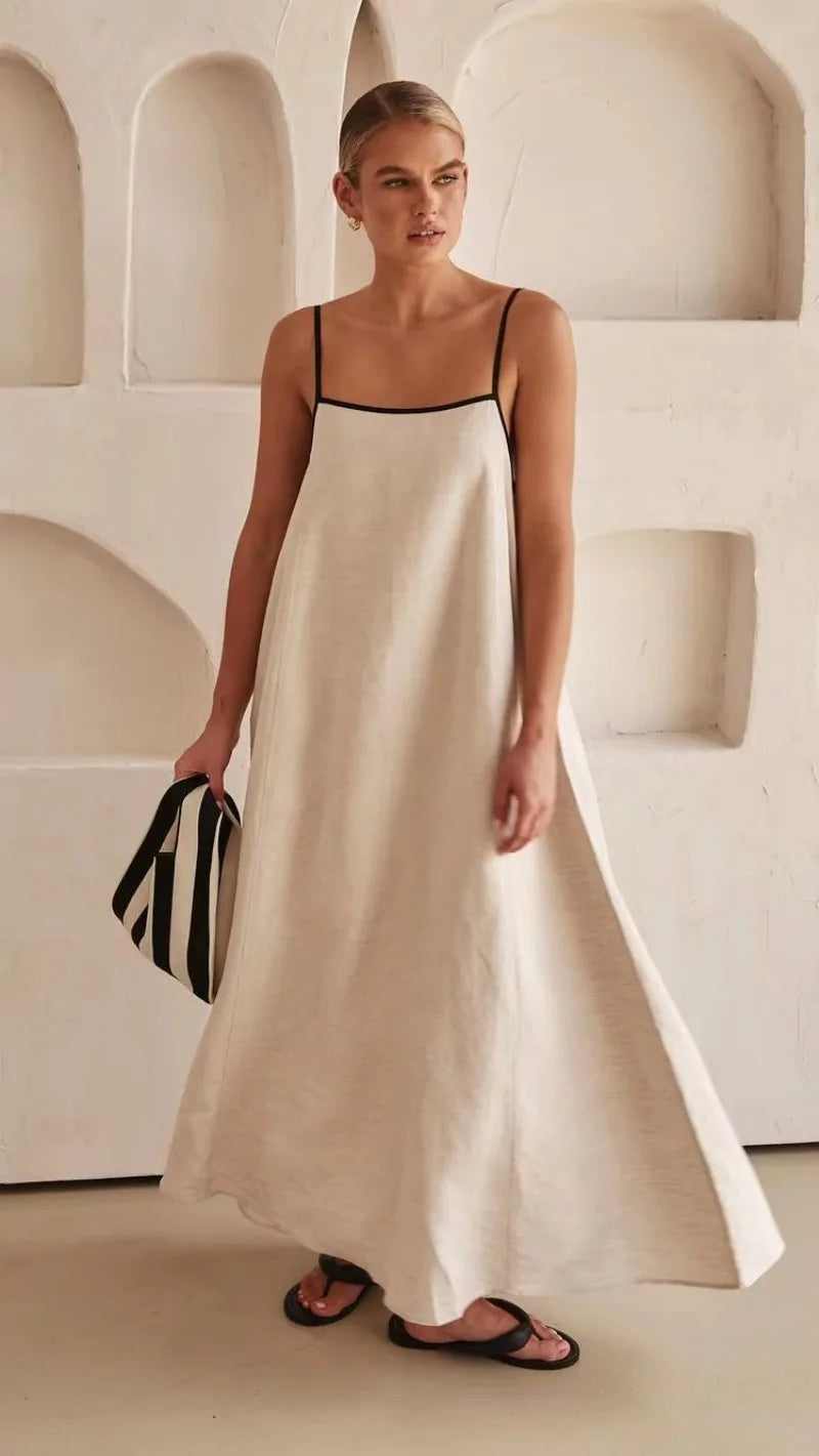 Vestido midi off-white com alças finas em ambiente minimalista, ideal para ocasiões casuais sofisticadas.
