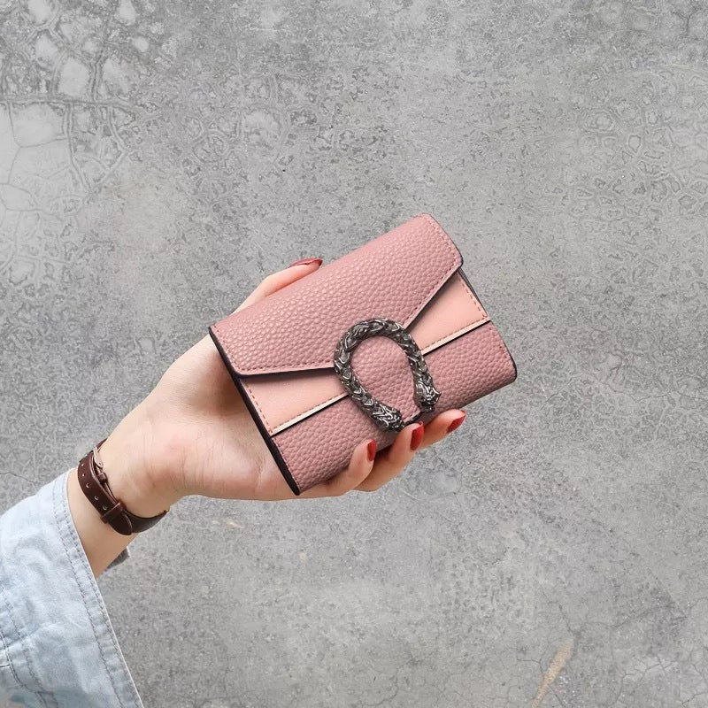 Carteira compacta em rosa blush com fecho metálico escultural. Um toque delicado e feminino para o seu visual.