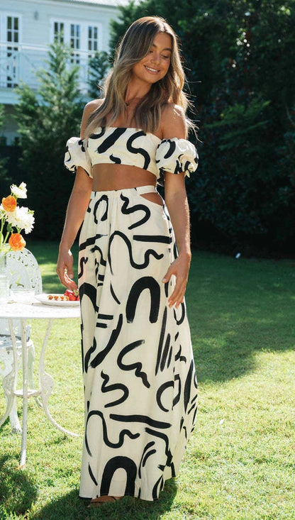 Modelo usando o Conjunto Ipanema, com top de manga bufante e saia longa, em pose elegante e frontal, destacando a modernidade da estampa abstrata.