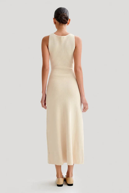 Parte de trás do Vestido Eloise em tricô bege, com acabamento limpo e comprimento midi.