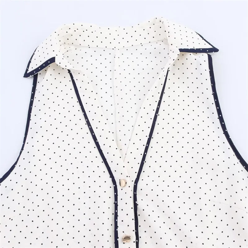 Close da gola estruturada e botões do Vestido Diora, com acabamento em viés azul marinho e estampa de poás delicados

