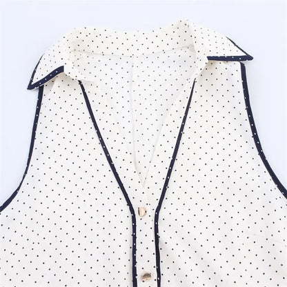 Close da gola estruturada e botões do Vestido Diora, com acabamento em viés azul marinho e estampa de poás delicados

