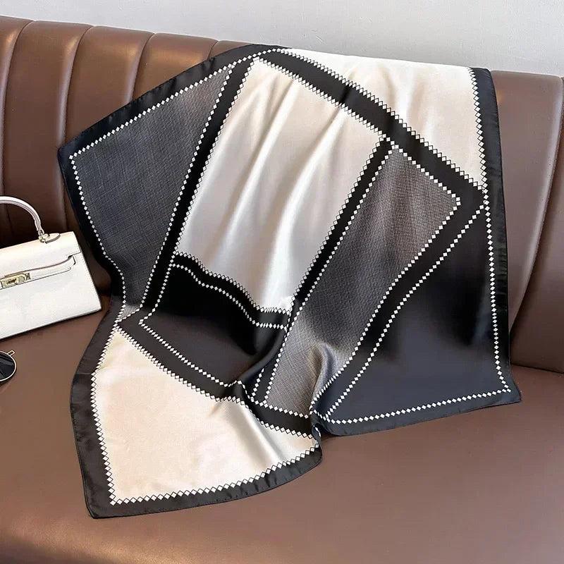 Lenco preto com moldura cinza clara em estilo minimalista, dobrado sobre banco de couro