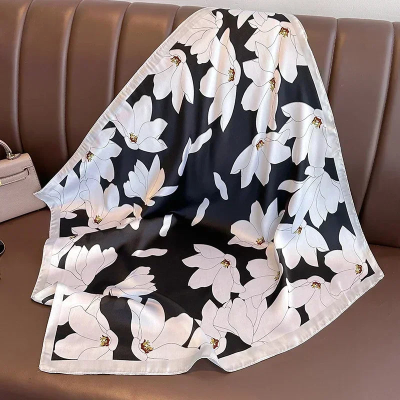 Lenco preto com estampa floral branca abstrata, em composicao sobre assento marrom