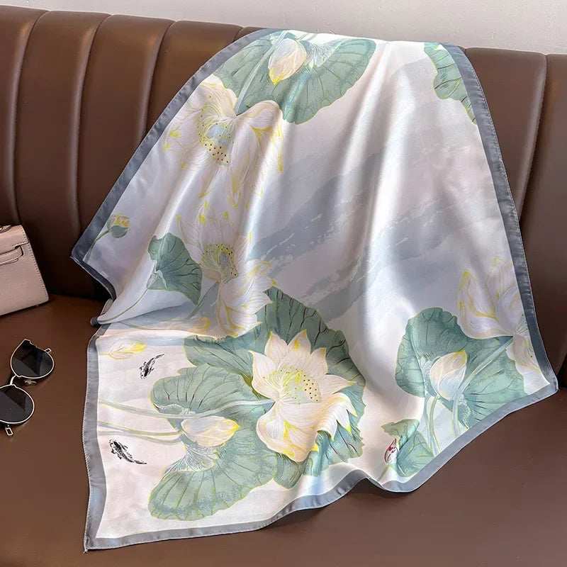 Lenco Versatile Grace acetinado em prata claro com estampa floral branca e verde, sobre banco marrom

