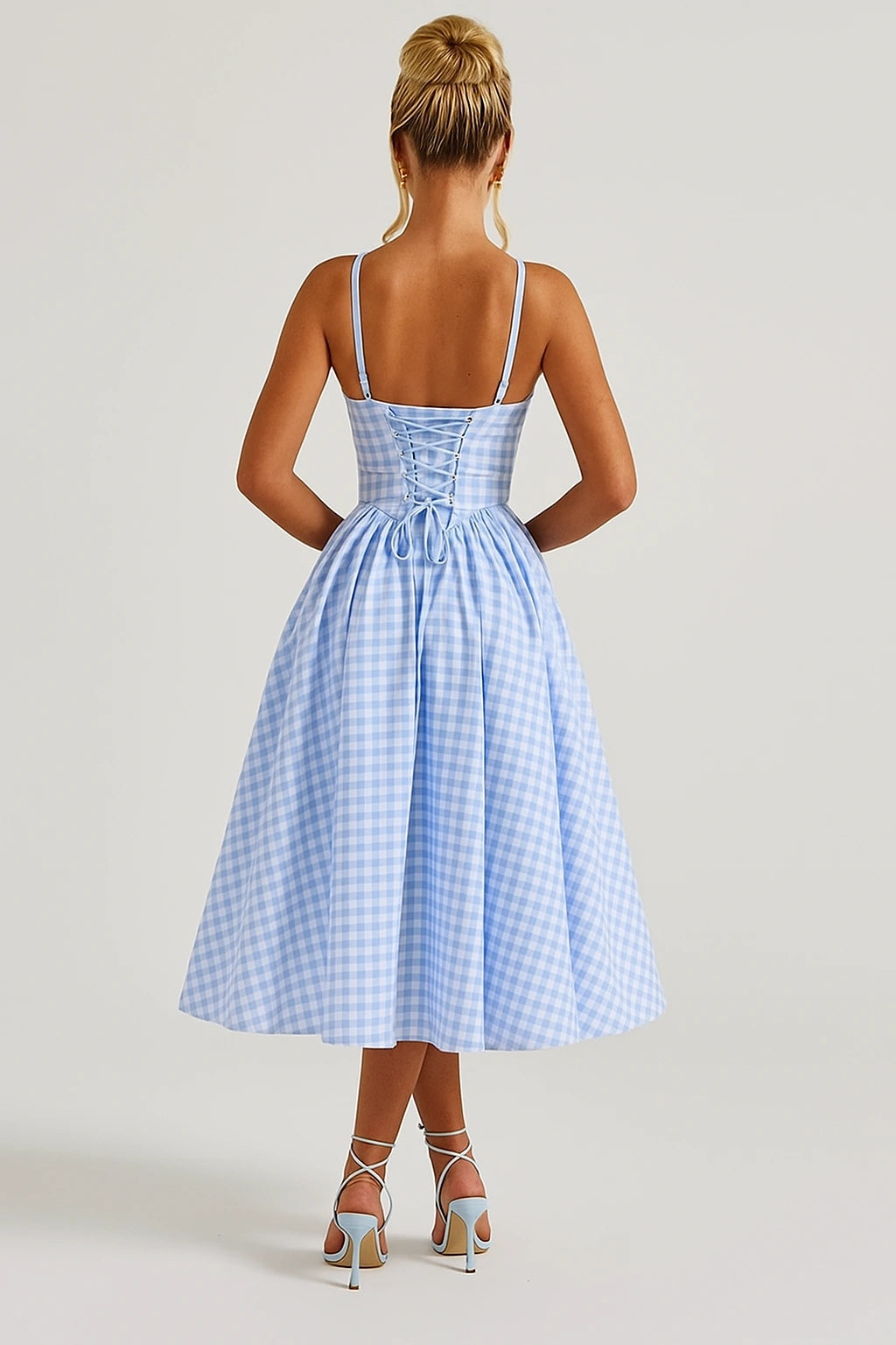 Vista traseira de vestido azul com amarração corset e saia midi volumosa
