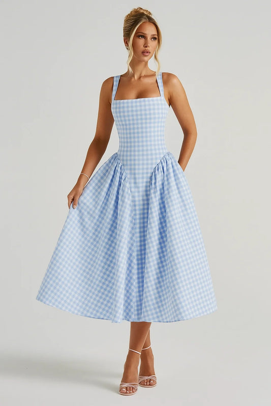 Mulher posando com vestido azul de alças largas e saia ampla, girando levemente