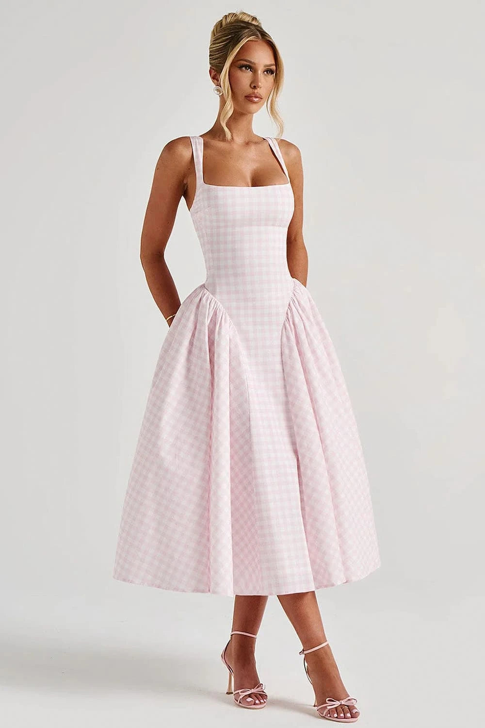 Modelo em pose frontal exibindo vestido rosa midi com saia ampla xadrez
