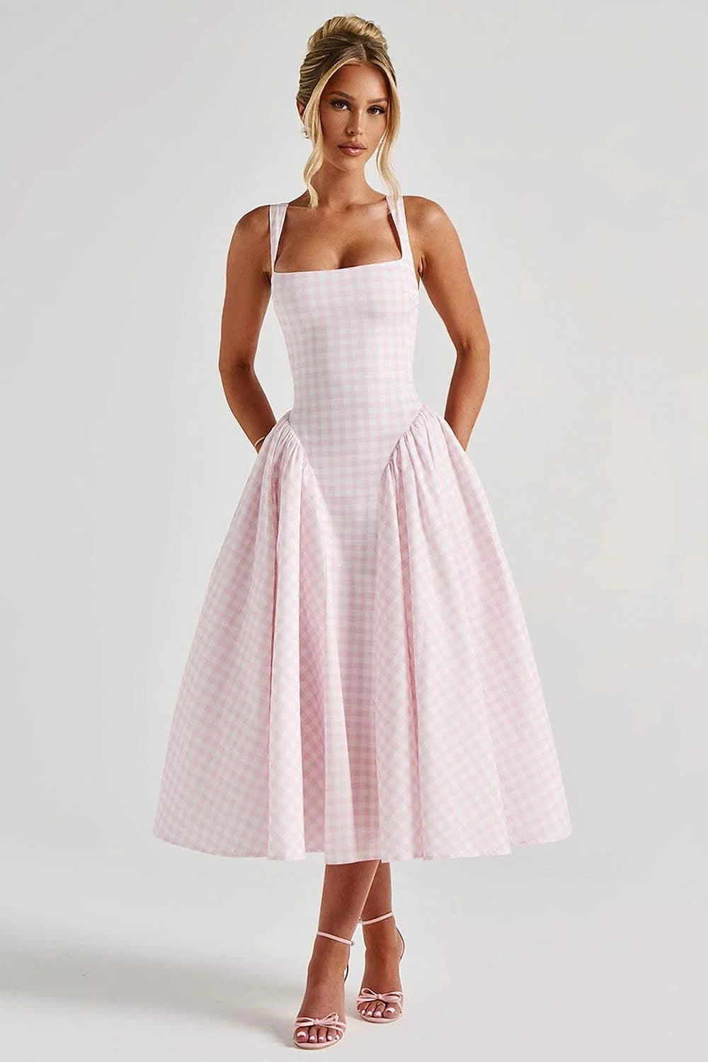 Modelo usando vestido midi rosa com estampa xadrez e decote quadrado