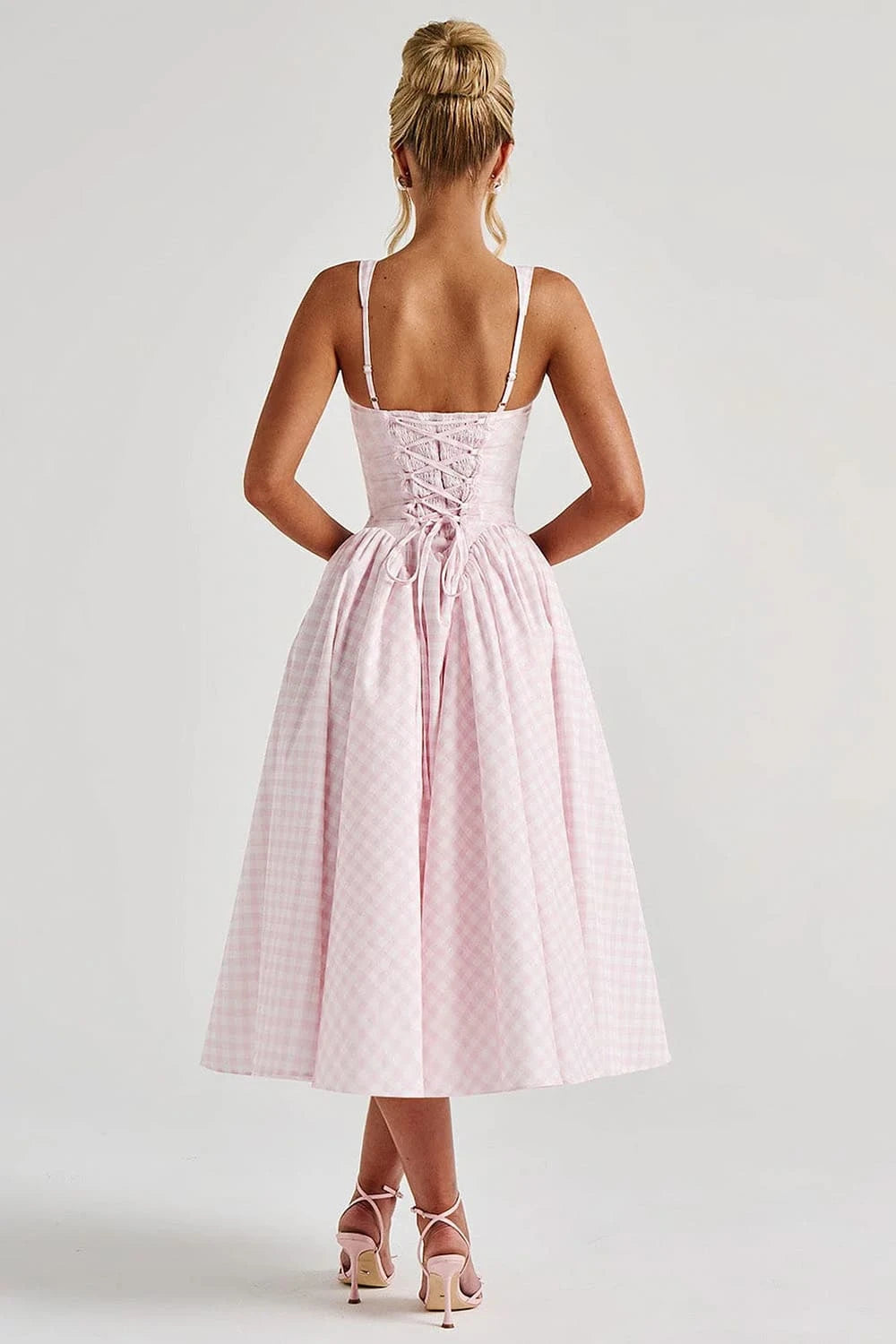 Vista traseira do vestido midi rosa com estampa xadrez e amarração tipo corset


