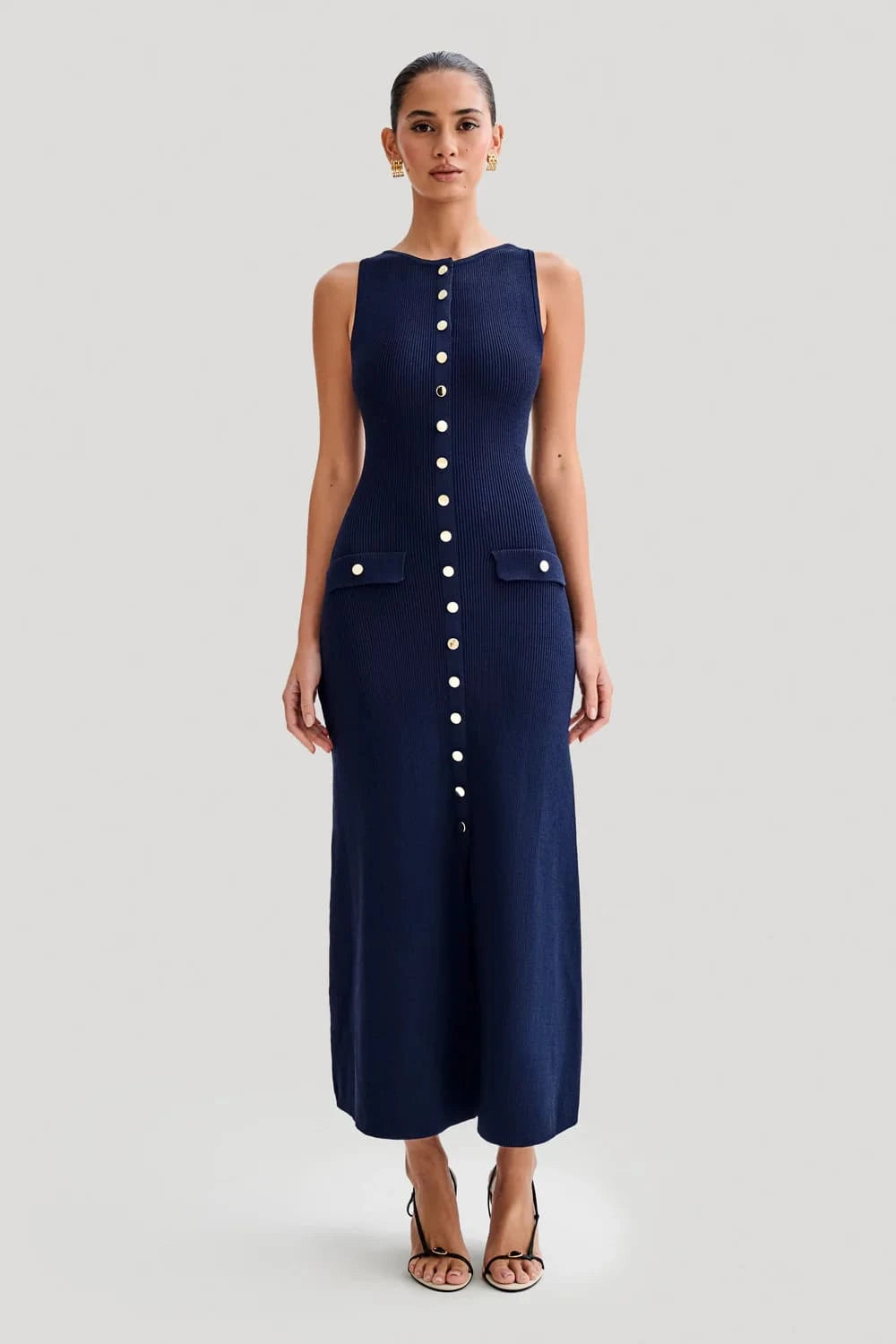 Vestido Eloise azul marinho, com bolsos frontais e botões metálicos, usado por modelo em fundo branco.
