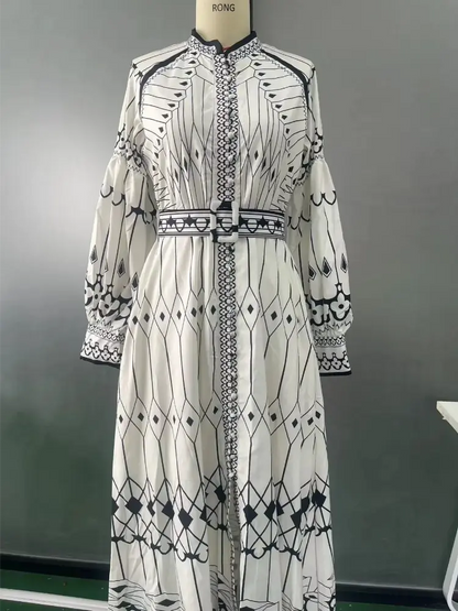 Vestido midi geométrico com cinto, exibido em manequim, mostrando a parte traseira e a estampa.