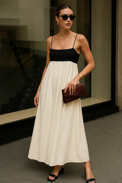 Mulher elegante com o Vestido Milano em ambiente urbano, usando clutch vinho e óculos escuros para compor um visual sofisticado.