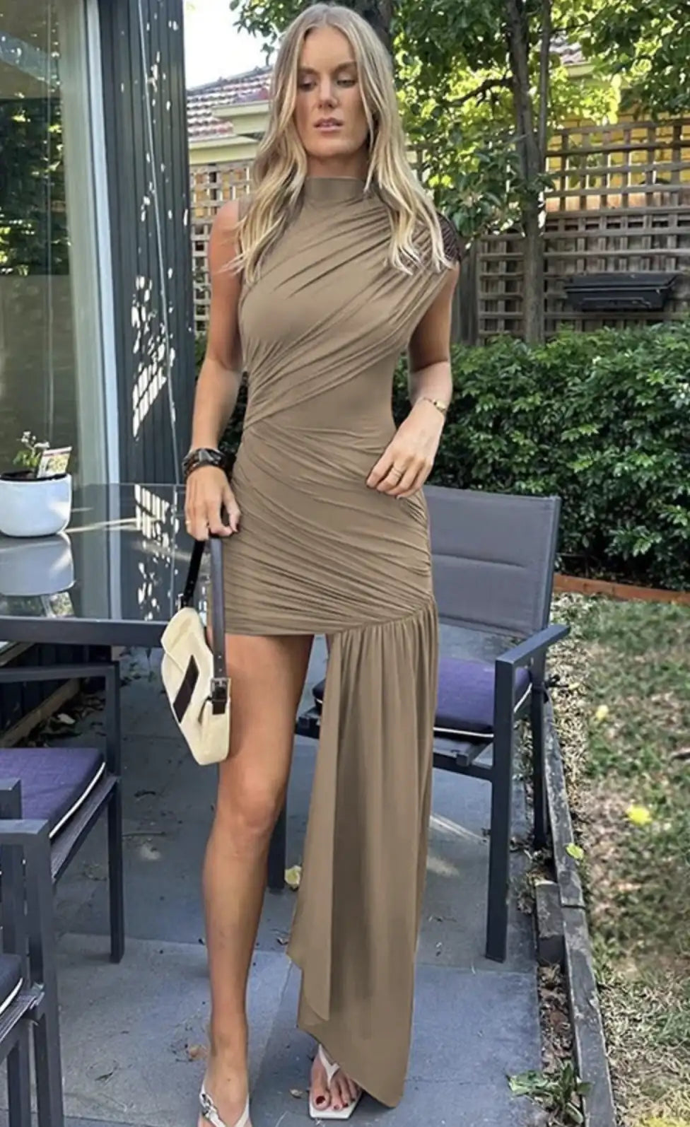 Modelo usando o Vestido Thalia nude em um ambiente interno, ideal para mostrar como a peça se adapta a ocasiões elegantes e sofisticadas, como festas e coquetéis.