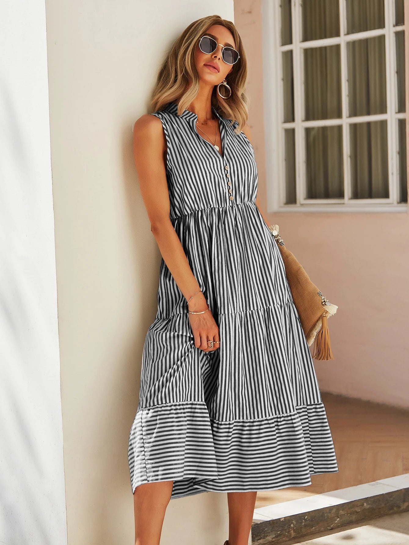 Vestido midi listrado em preto e branco, com recorte fluido e modelagem que valoriza a silhueta. Elegância casual para o dia a dia.


