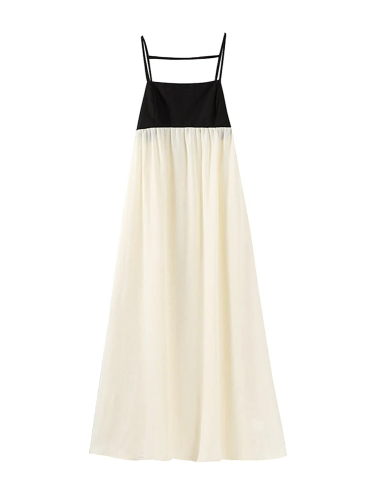 Imagem do Vestido Milano pendurado, destacando o design bicolor com busto preto e saia fluida off-white.