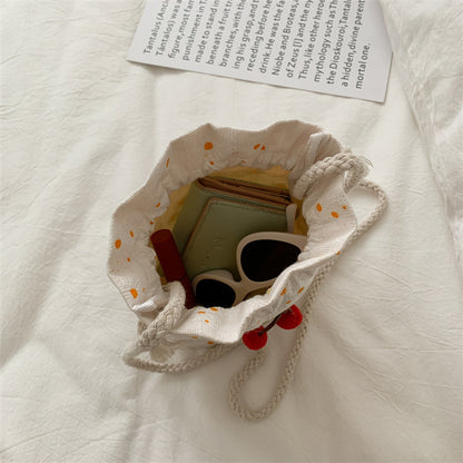 Bolsa Cherry de lona aberta mostrando espaço interno para celular e acessórios do dia a dia.