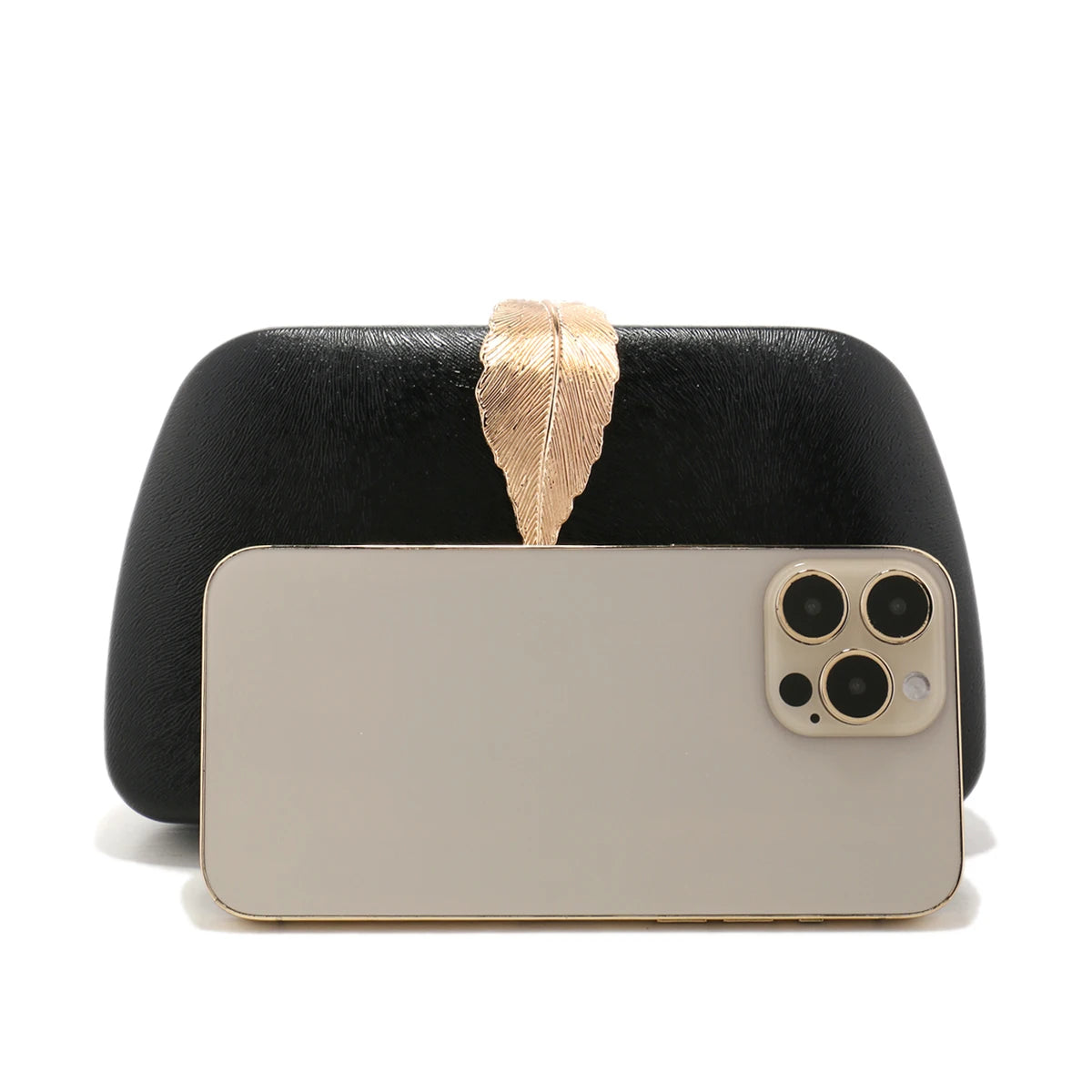 Clutch preta com folha dourada ao lado de celular, mostrando tamanho compacto perfeito para eventos.