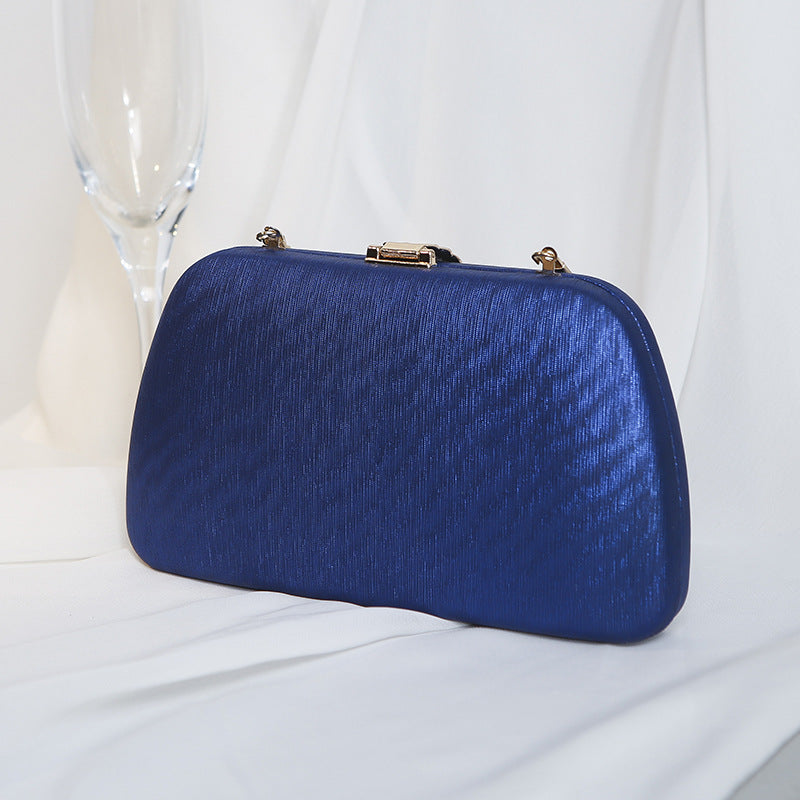 Bolsa clutch estruturada com acabamento texturizado e fecho metálico superior, acessório elegante para festas, casamentos e eventos especiais.