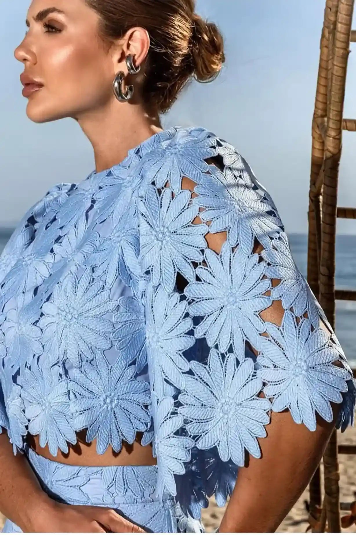 Detalhe do Conjunto Antonella visto de perfil, focando na delicadeza da renda floral artesanal e no caimento fluido da saia. A imagem mostra a versatilidade e a leveza do look.