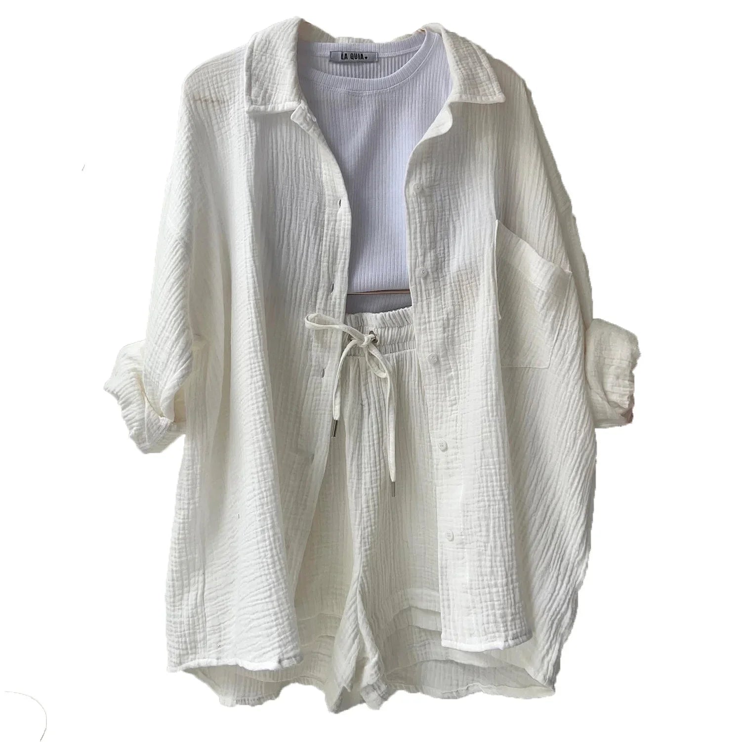 Conjunto branco feminino com camisa e shorts de tecido leve texturizado.