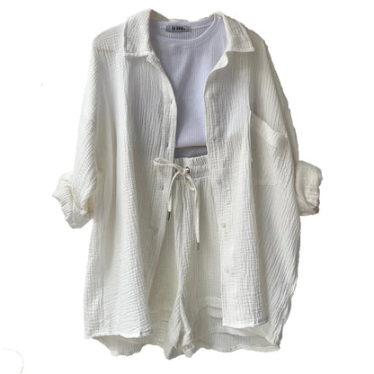 Conjunto branco feminino com camisa e shorts de tecido leve texturizado.