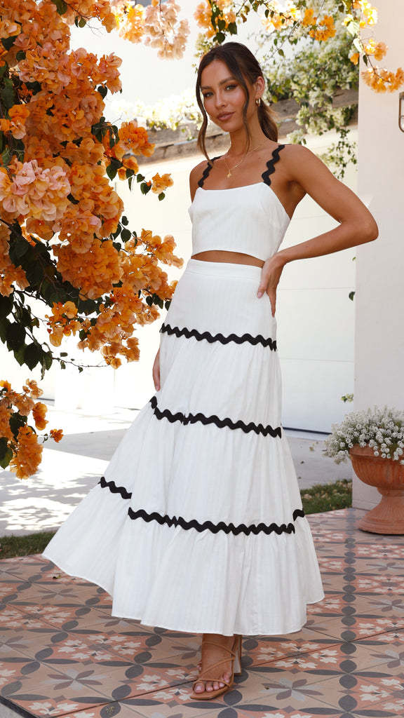 Conjunto branco elegante com top cropped e saia midi, ambos com acabamento ondulado preto em contraste
