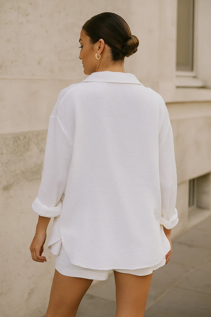 Modelo de costas usando conjunto branco minimalista com textura leve e caimento solto.