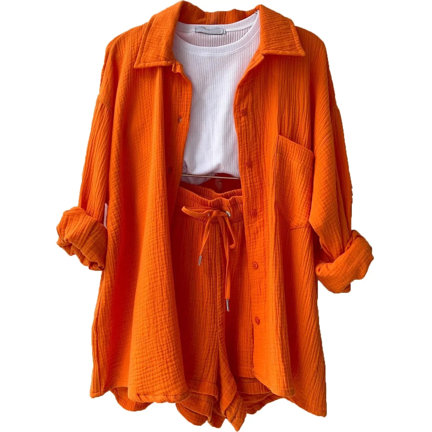 Conjunto laranja vibrante com camisa de botões e shorts com cordão, visual moderno e ousado para o verão.