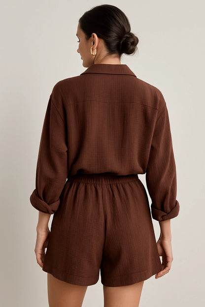 Vista traseira do conjunto marrom com camisa ampla e shorts de cintura alta, cabelo preso em coque elegante.