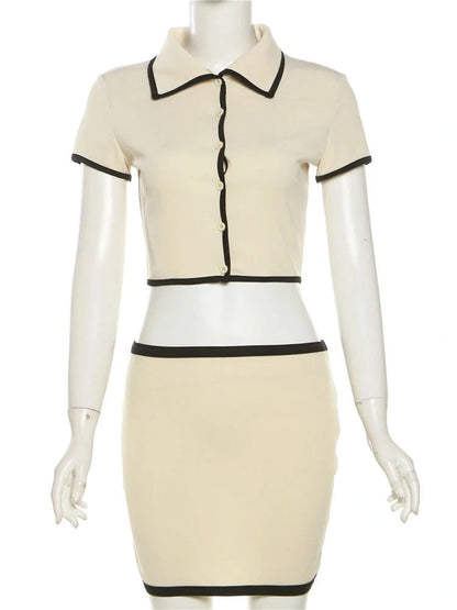Vista frontal do conjunto feminino com gola estruturada e acabamento preto contrastante, em manequim