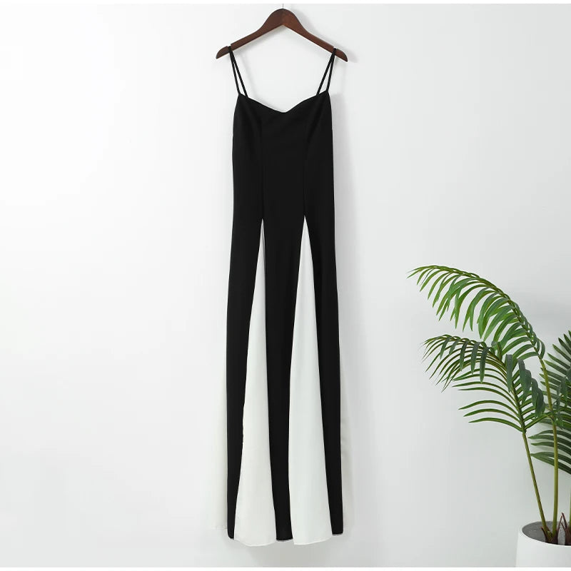 Vestido Adele preto e branco pendurado em cabide, com visual clean e recortes simétricos em destaque.