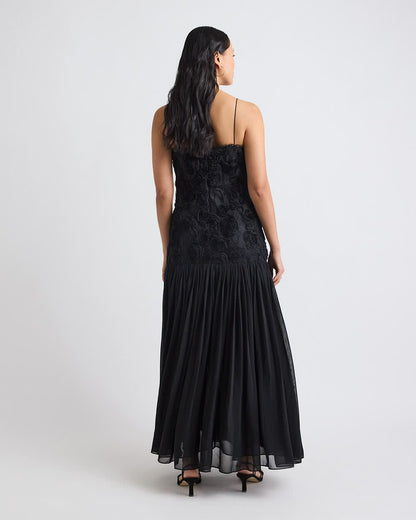 Vista traseira do Vestido Ágata preto, com alças finas, zíper invisível e saia plissada longa.