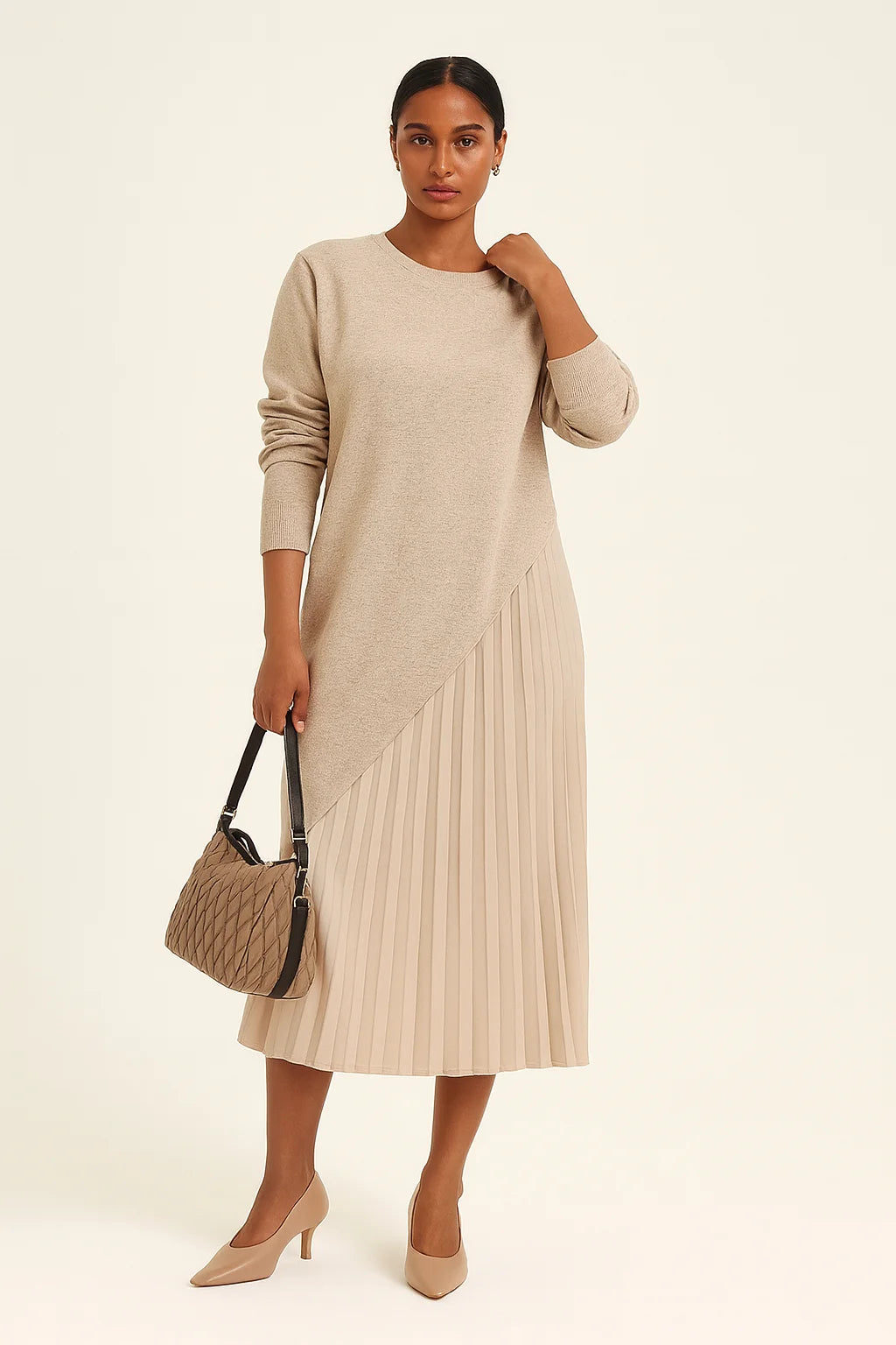 Mulher morena clara vestindo vestido bege com sobreposição assimétrica e saia plissada em estúdio claro. Look elegante e sofisticado da Dress Eleven.