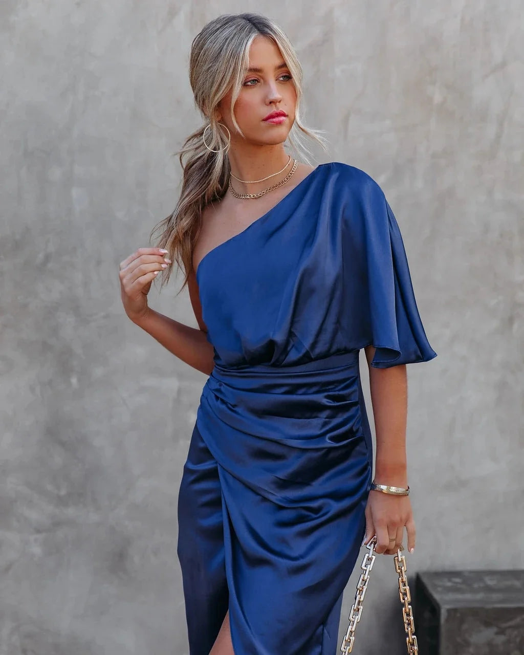 Vestido Athena midi de um ombro só azul, corte assimétrico que alonga a silhueta.