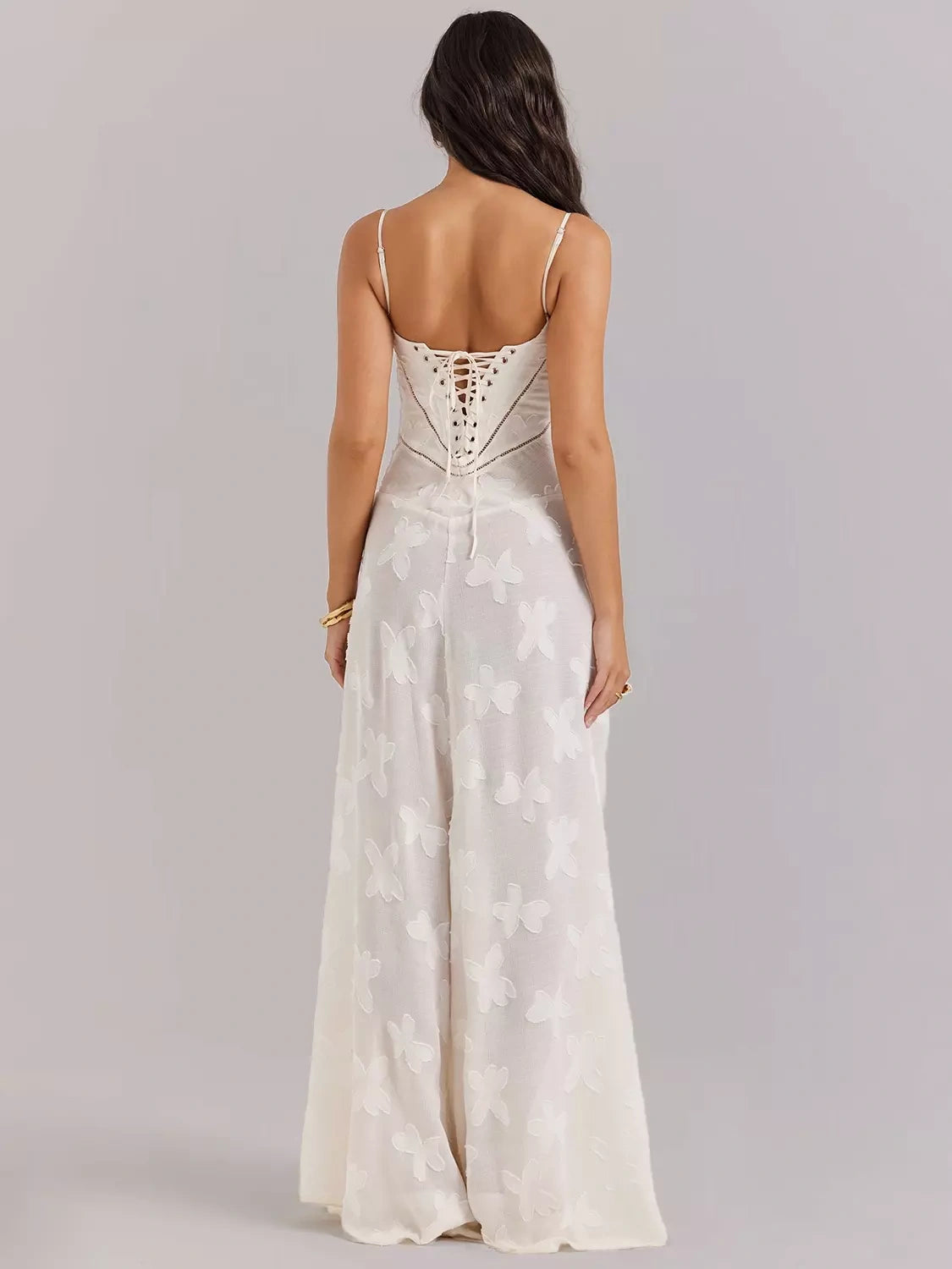 Vestido longo Aveline com amarração ajustável nas costas e bordados florais delicados, fundo neutro.