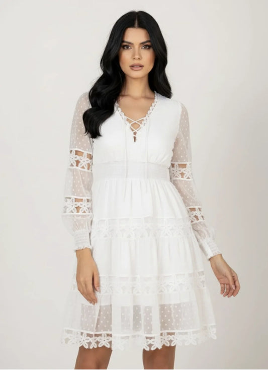 Modelo vestindo o Vestido Curto Guipir Creta branco da Dress Eleven com mangas longas em tule e detalhes em renda guipir.