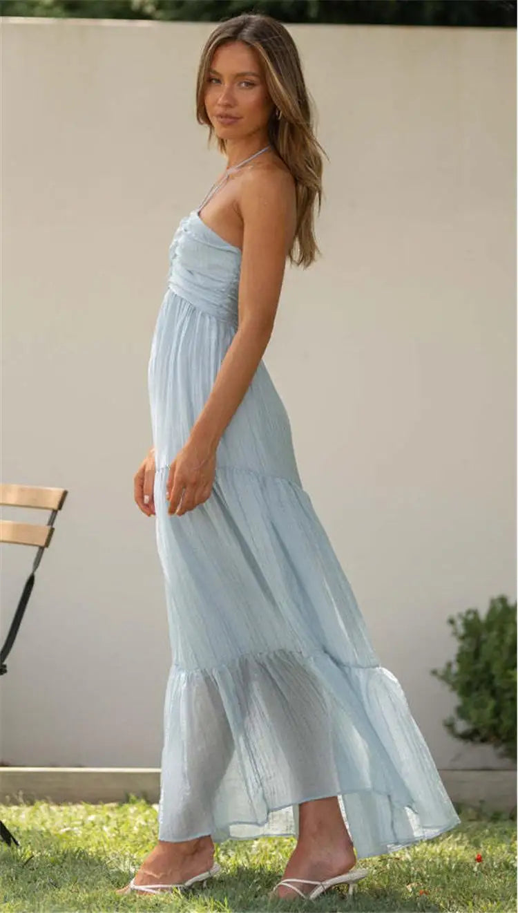 Vestido Diane azul em chiffon, visão lateral, com decote halter e movimento fluido na saia longa