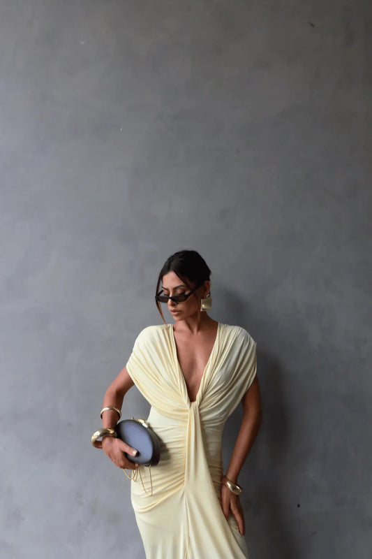 Modelo com Vestido Longo Desirée Dress Eleven posando com clutch preta e salto alto, estilo refinado.