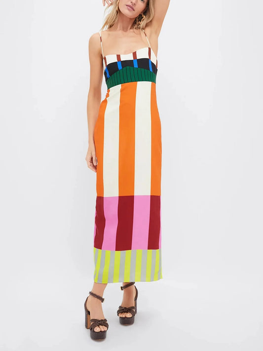 Mulher usando vestido longo estampado com listras verticais coloridas, vista frontal