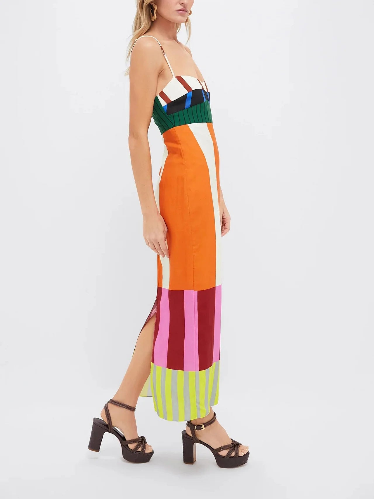 Modelo em perfil vestindo vestido colorido com caimento reto e estampa geométrica