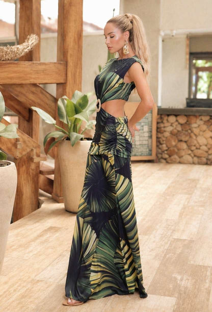 Vestido Longo Eva Dress Eleven estampa de folhagem verde e amarela. Modelo de frente destacando a fivela artesanal na cintura e modelagem ajustada em malha fluit.