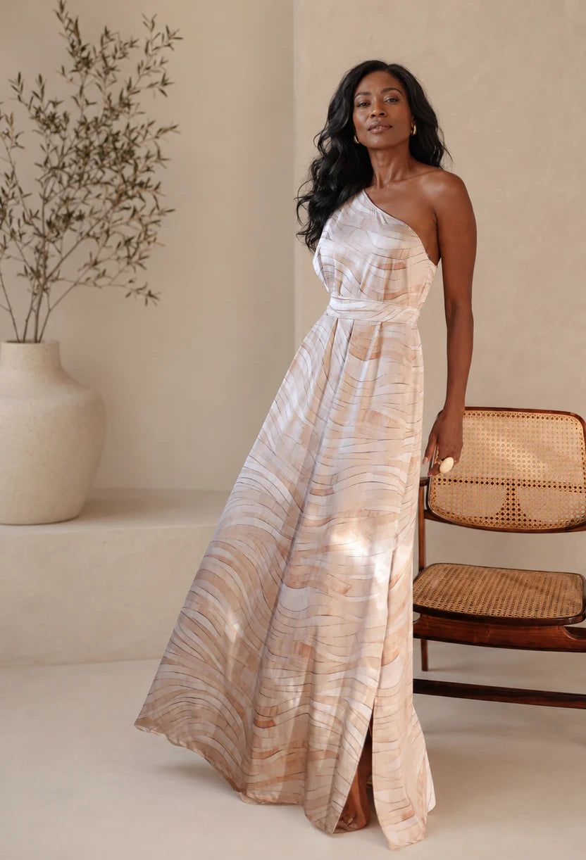 Vestido longo Íris Dress Eleven estampado em tons areia, um ombro com fenda, vista frontal.
