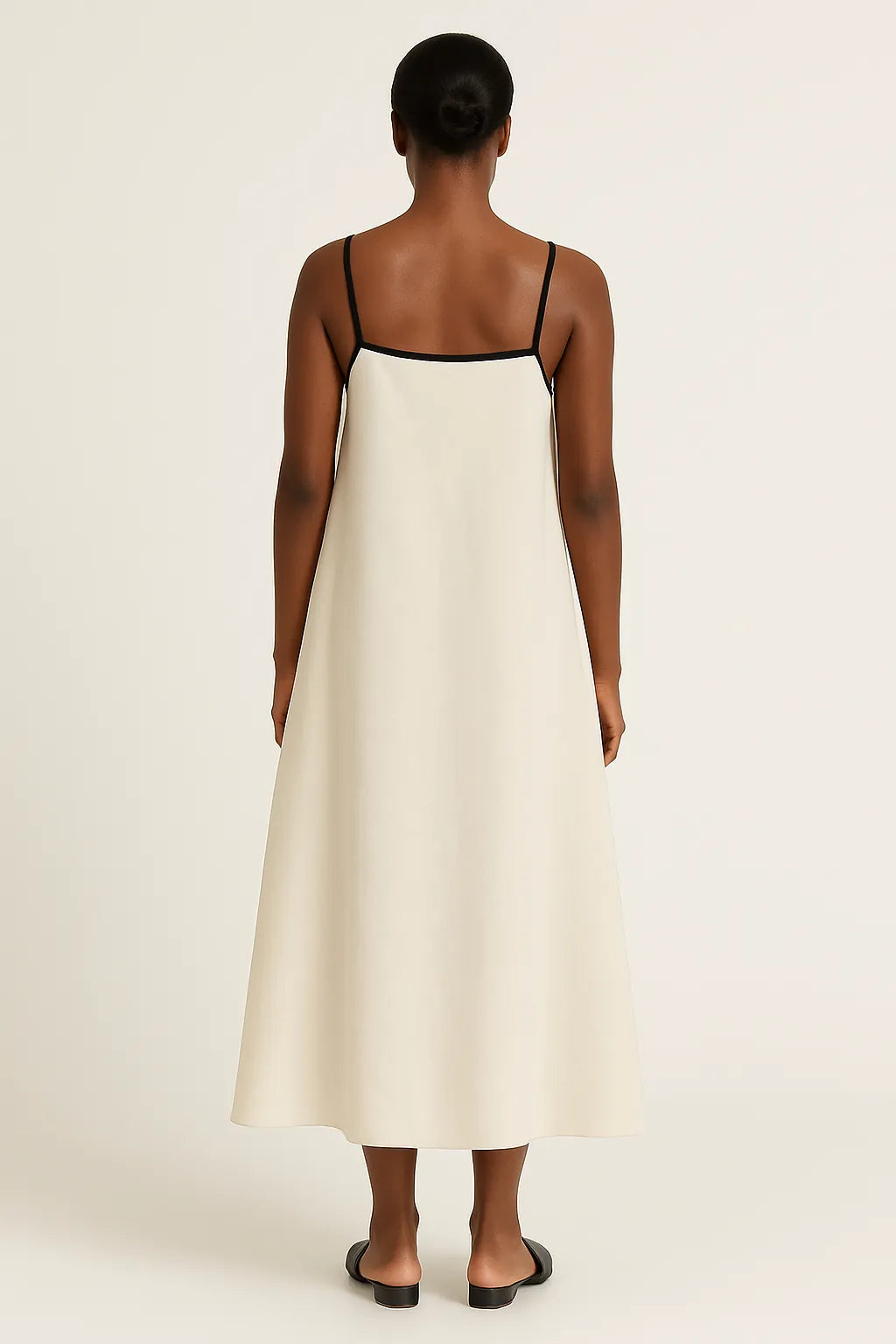 Vestido midi com alças finas visto de costas, com modelagem ampla e acabamento reto nas costas.