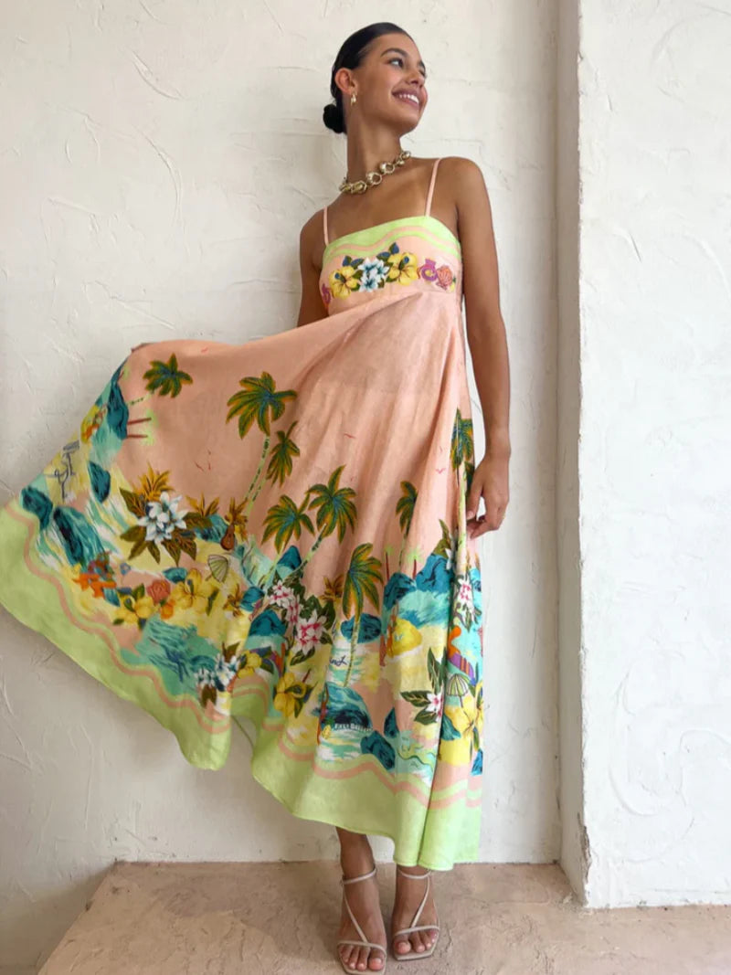 Vestido midi tropical com estampa praiana e barra colorida, modelo girando para mostrar a saia esvoaçante.